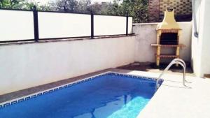 a swimming pool with a bench next to a building at Casa Rural Sara in Pinos del Valle