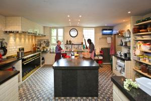 two people in a kitchen with a large island in it at Rosario in Bever