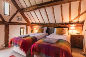 a bedroom with two beds in a attic at Meadow End Barn in Dorstone