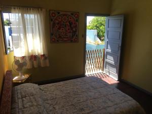 um quarto com uma cama e uma porta com uma janela em TERRAZAS DEL SUR em Ezpeleta