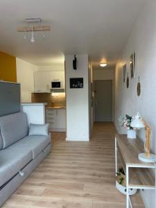 ein Wohnzimmer mit einem Sofa und einer Küche in der Unterkunft Studio Roma in Straßburg