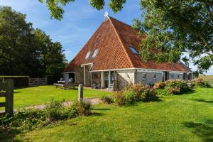 a house with a red roof on a green yard at Iselmarpleats 3 kamer appartement in Gaast