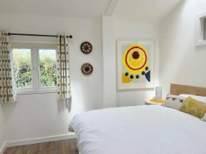 a white bedroom with a bed and a window at The Garden Lodge in Shaldon