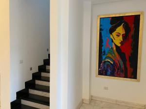 a painting of a woman on a wall next to stairs at Luxury Allegria Golf Villa with pool in Sheikh Zayed