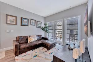 a living room with a leather couch and a table at 1 Luxury Apartment in Los Angeles