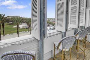 a balcony with chairs and a view of the ocean at Beach and Gulf Views from the Center of Seaside! condo in Santa Rosa Beach
