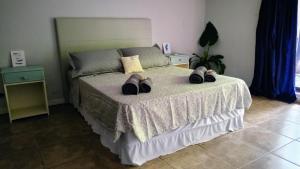 ein Schlafzimmer mit einem Bett mit Schuhen drauf in der Unterkunft Selva mia in Puerto Iguazú