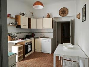 una cucina con armadi bianchi e tavolo bianco di San Rocco Country House a Pesaro