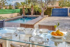 una mesa de cristal con un bol de fruta junto a una piscina en zen villa by villasmediterranean en El Toro