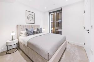 Un dormitorio blanco con una cama grande y una ventana en *Rare Find* Luxury London Collection, en Londres