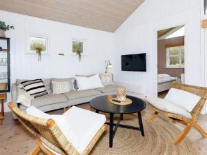 Three-Bedroom Holiday home in Øster Assels 3 في Sillerslev: غرفة معيشة مع أريكة وطاولة