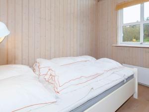 um quarto com 2 camas com lençóis brancos e uma janela em Three-Bedroom Holiday home in Øster Assels 3 em Sillerslev