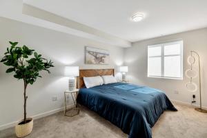 a bedroom with a bed with a blue bedspread at 5 Heart of Santa Monica apartment in Los Angeles