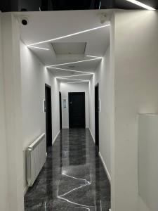 un couloir avec des murs blancs et une porte noire dans l'établissement MONARC Boutique ApartHotel - SELF CHECK-IN, à Iaşi