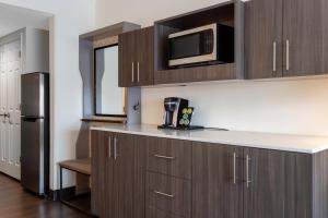 uma cozinha com armários de madeira e um micro-ondas em Holiday Inn - Tampa North, an IHG Hotel em Tampa