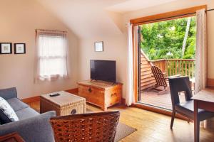 a living room with a couch and a television and a balcony at Island City House in Key West