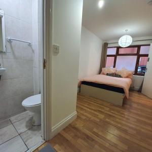 a bathroom with a bed and a shower and a toilet at All saints Rooms in London