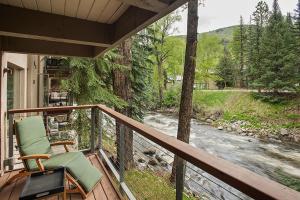 a porch with two chairs and a river at Chateau Eau Claire 9, Newly Renovated Condo with River Views, Hot Tub, Pool, Fitness Center Access in Aspen