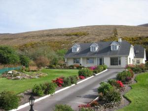 a house with a garden and a hill in the background at Glencurrah House B&B in Glenbeigh