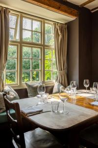 a dining room with a table with wine glasses on it at The Ebrington Arms in Chipping Campden