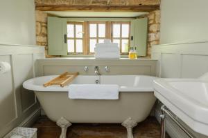 a bathroom with a white tub and a sink at The Ebrington Arms in Chipping Campden