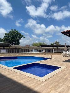 a large swimming pool with a wooden deck and a blue at Lindo apartamento in Aracaju