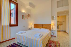 ein Schlafzimmer mit einem Bett mit Handtüchern darauf in der Unterkunft MORETTA get-by-train in Venedig