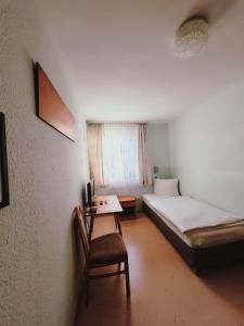 a room with two beds and a table and a chair at City Hotel Bauer mit Aufzug with elevator in Nürnberg