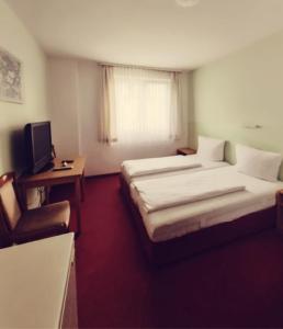 a hotel room with two beds and a television at City Hotel Bauer mit Aufzug with elevator in Nürnberg