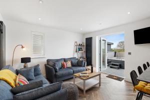 a living room with a couch and a table at The Paddock - Lovely Cottage with Hot Tub in Penally