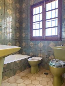 een badkamer met een toilet, een wastafel en een raam bij Casa Aya in Teror