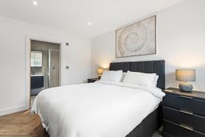 a bedroom with a large bed and a dresser at The Paddock - Lovely Cottage with Hot Tub in Penally +26 photos