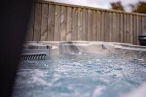 a tub with water on top of a fence at The Paddock - Lovely Cottage with Hot Tub in Penally
