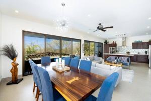 uma sala de jantar com uma mesa e cadeiras azuis em Casa Blanca em Playa Hermosa