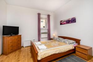 a bedroom with a bed and a flat screen tv at Hostel Koral in Szczecin