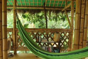 a hammock in a room with a book shelf at Sol de Minca Eco Lodge in Minca