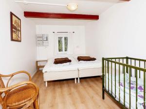 1 dormitorio con 1 cama y 2 sillas en Luxurious Holiday Home in Thyholm with Sauna en Thyholm