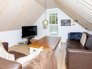 a living room with a couch and a tv at Luxurious Holiday Home in Thyholm with Sauna in Thyholm
