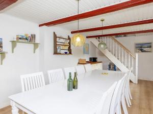 ThyholmにあるLuxurious Holiday Home in Thyholm with Saunaの白いダイニングルーム(白いテーブルと椅子付)