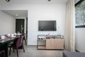 uma sala de jantar com uma mesa e uma televisão na parede em Moderno apartamento, 2 quartos em Belo Horizonte