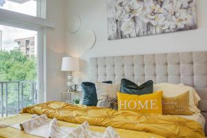 a bedroom with a bed with a yellow blanket and a window at Luxury Living Downtown Houston Kingbed. in Houston