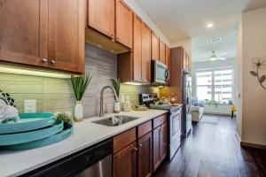 a kitchen with wooden cabinets and a sink at Luxury Living Downtown Houston Kingbed. in Houston