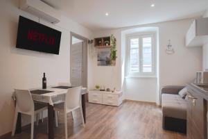 a kitchen and living room with a table and chairs at [Largo Barriera] Elegant Apartment *Netflix+WiFi* in Trieste
