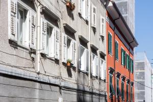 a building with white shuttered windows on a street at [Largo Barriera] Elegant Apartment *Netflix+WiFi* in Trieste
