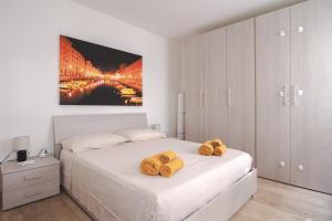 a white bedroom with a bed with towels on it at [Largo Barriera] Elegant Apartment *Netflix+WiFi* in Trieste