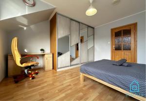 a bedroom with a bed and a desk and a chair at ZigZag Room in Gdańsk