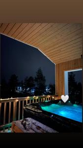 bañera de hidromasaje en el balcón por la noche en Villa Golden House en Rovaniemi