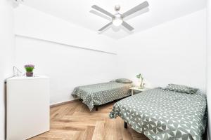 a bedroom with two beds and a ceiling fan at Sea la vi in Puerto Rico de Gran Canaria