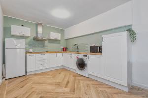 a kitchen with white cabinets and a washer and dryer at Sea la vi in Puerto Rico de Gran Canaria +5 photos