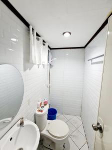 Un baño blanco con inodoro y lavabo. en Calapan City Fully Furnished House Transient near XentroMall L39, en Calapan
